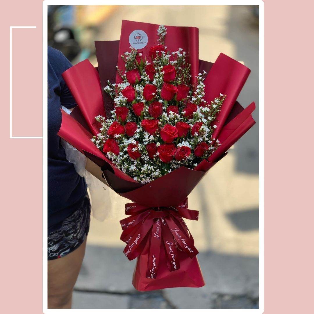 Bouquet of red roses wrapped in red paper with a blurred background