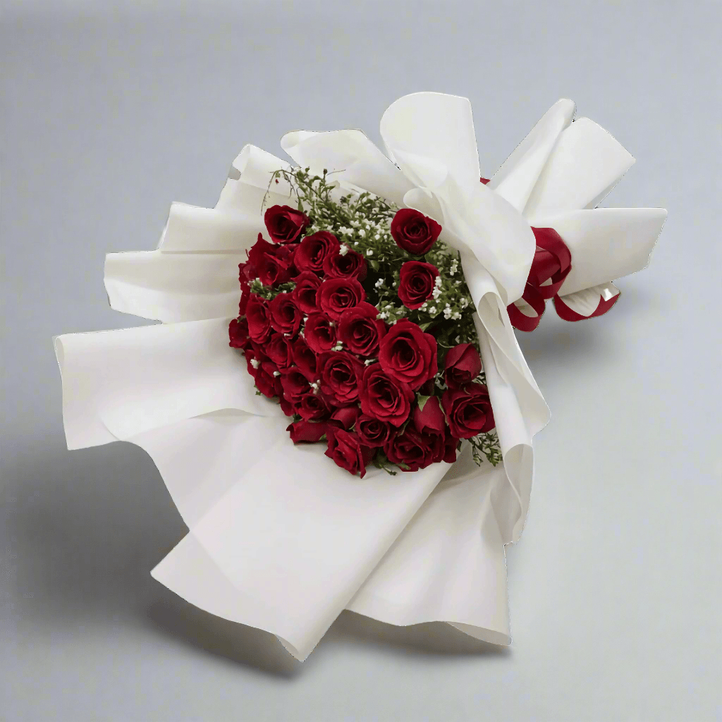Bouquet of red roses wrapped in white paper on a light gray background