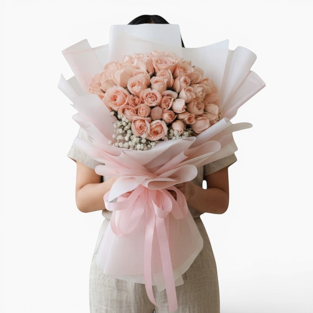 The Flowercart Mardi Gras bouquet featuring 50 premium pink roses and baby's breath wrapped in pink and white paper.