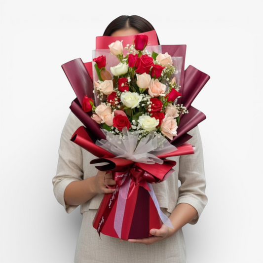 The Flowercart Hermosa bouquet: 24 red, white, and pink roses with baby's breath, elegantly wrapped in burgundy.