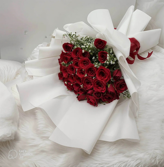 Bouquet of red roses shaped like a heart with white ribbons on a white background