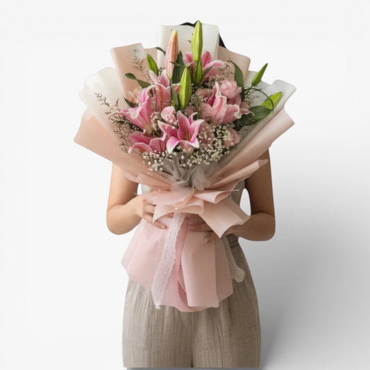 The Flowercart Star Lily bouquet features pink Stargazer lilies, pink roses, baby's breath, and misty blue fillers, elegantly wrapped.
