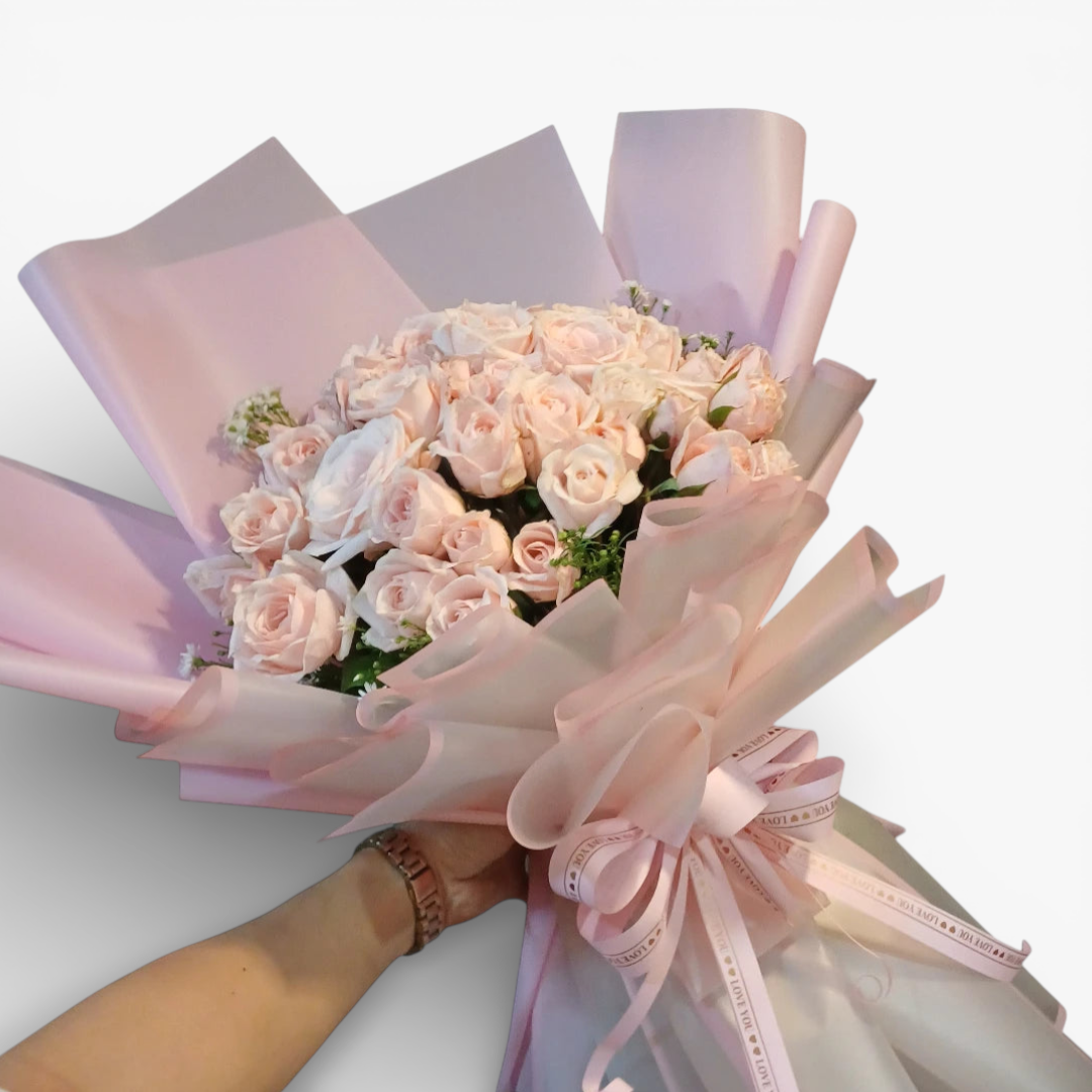 The Flowercart Mardigrass bouquet with 50 premium light pink roses, elegantly wrapped in pink paper and tied with a 'love you' ribbon.
