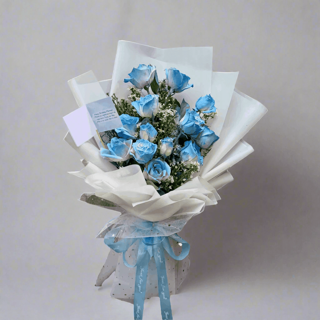 Bouquet of blue roses with white paper wrap and blue ribbon, branded 'The Flowercart'.