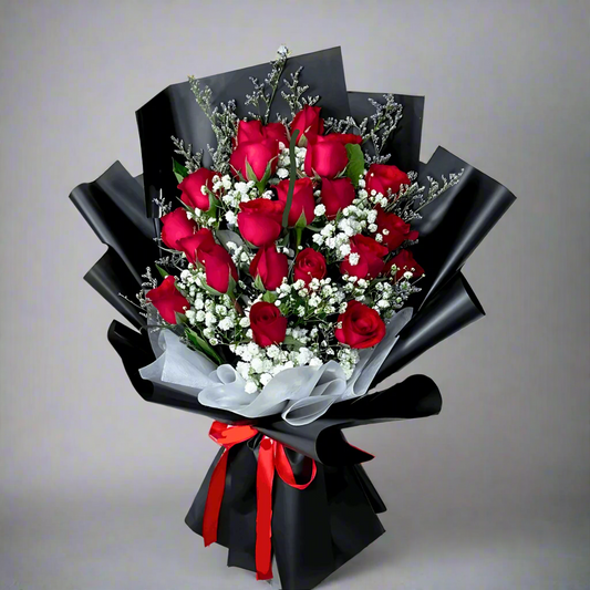 Bouquet of red roses with black wrap and red ribbon, displayed on a mannequin.