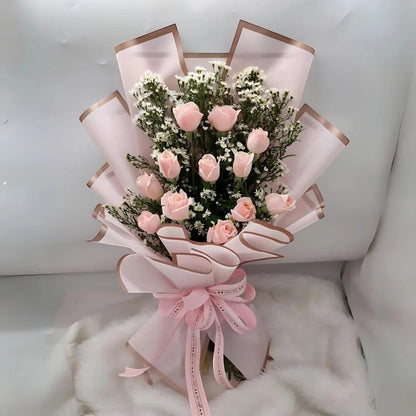 Bouquet of pink roses with a decorative bow on a white background