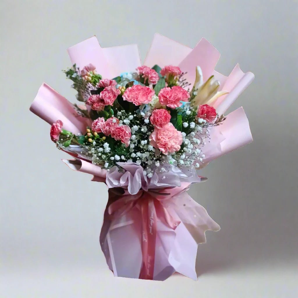Bouquet of pink flowers wrapped in pink paper on a light gray background