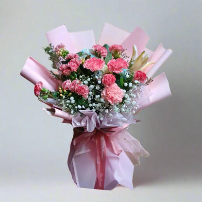 Bouquet of pink flowers wrapped in pink paper on a light gray background