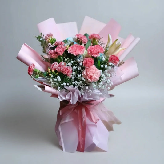 Bouquet of pink flowers wrapped in white paper with a pink ribbon on a white background