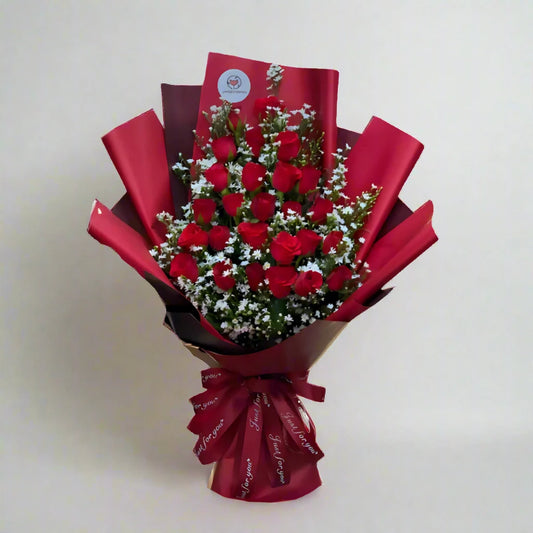 Bouquet of red roses wrapped in red paper on a light background