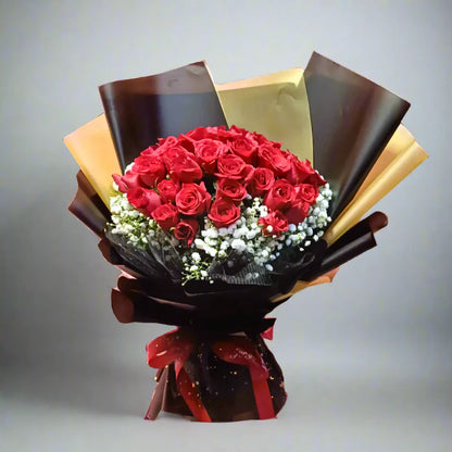Bouquet of red roses wrapped in brown paper with a red ribbon on a gray background
