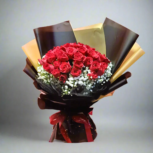 Bouquet of red roses wrapped in brown paper with a red ribbon on a gray background