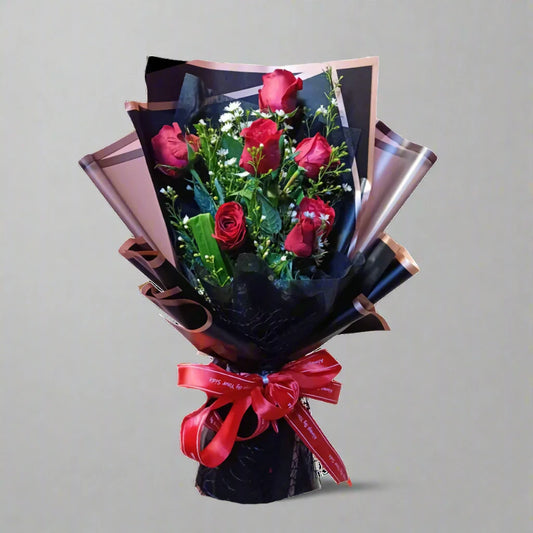 Bouquet of red roses with a red ribbon on a gray background