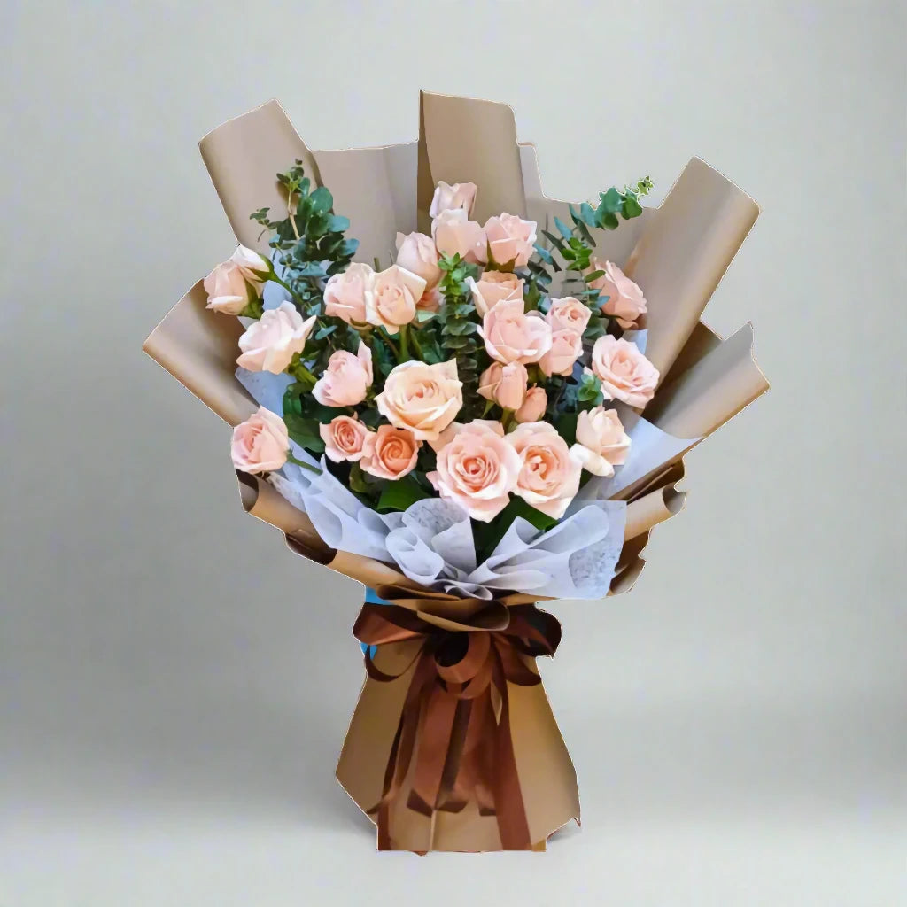 Bouquet of pink roses wrapped in brown paper with a white background