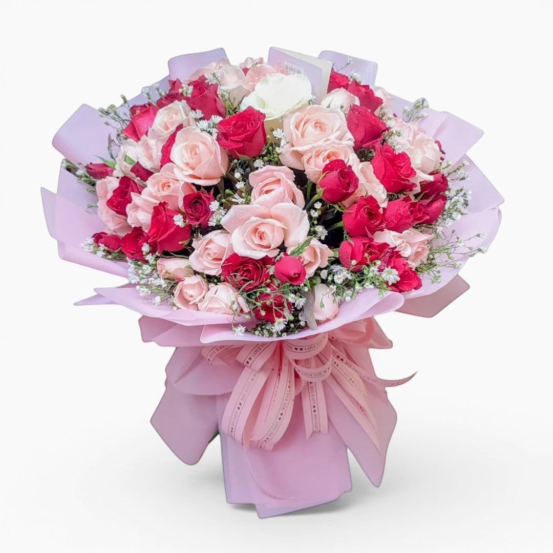 The Flowercart bouquet of 100 red and pink roses with baby's breath wrapped in elegant pink paper for anniversaries.
