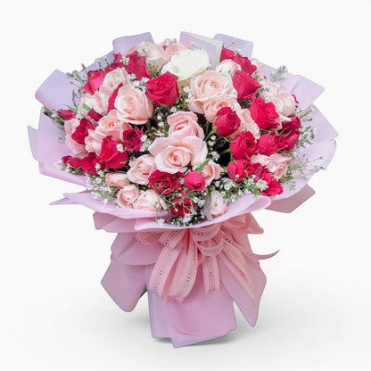 The Flowercart bouquet of 100 red and pink roses with baby's breath wrapped in elegant pink paper for anniversaries.