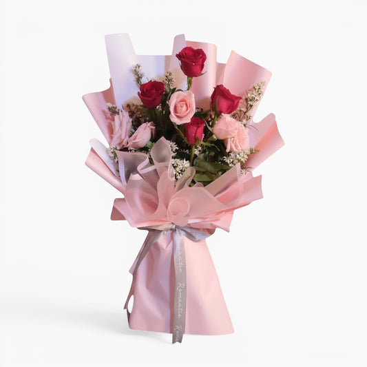 The Flowercart Caribbean Twist bouquet featuring red and pink roses wrapped in elegant light pink paper