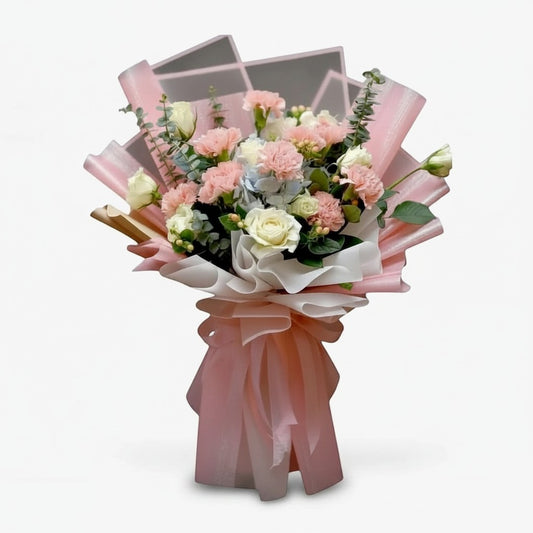 The Flowercart Carnation Carnival bouquet with pink carnations, white roses, blue hydrangeas, and fresh eucalyptus.