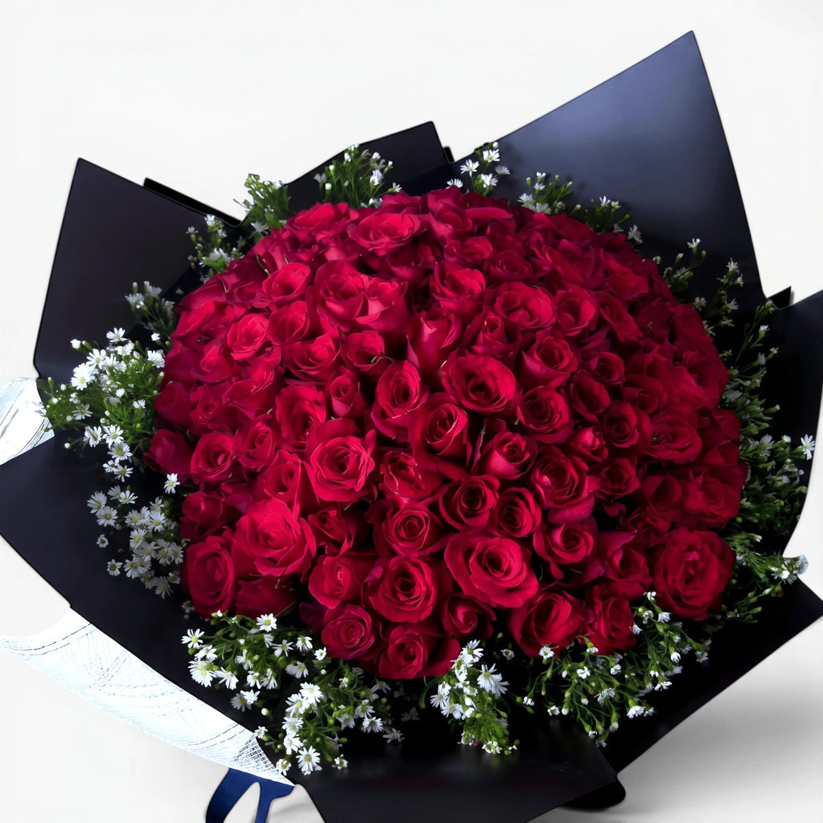 The Flowercart Meadow Fresh bouquet of 100 crimson roses and baby's breath wrapped in elegant black paper.
