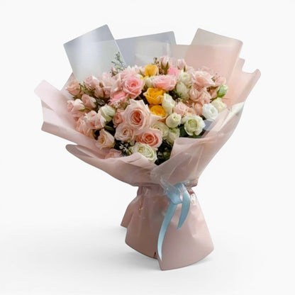 The Flowercart Fior di Luna bouquet featuring 100 yellow, white, and pink roses with baby's breath in pink wrapping.