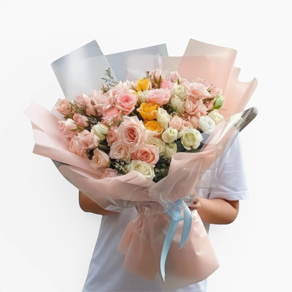 The Flowercart Fior di Luna bouquet featuring 100 yellow, white, and pink roses wrapped in soft pastel paper.