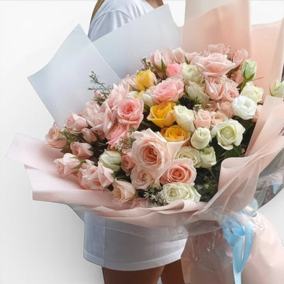 The Flowercart Fior di Luna bouquet with 100 yellow, white, and pink roses wrapped in soft pastel paper.