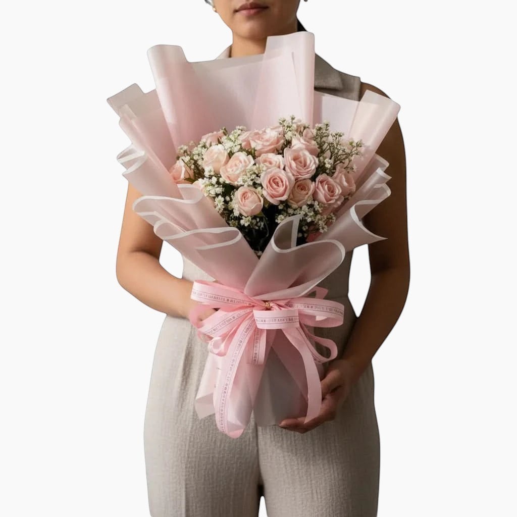 The Flowercart Dreaming of you bouquet featuring 24 pink roses and baby's breath wrapped in elegant pink paper.