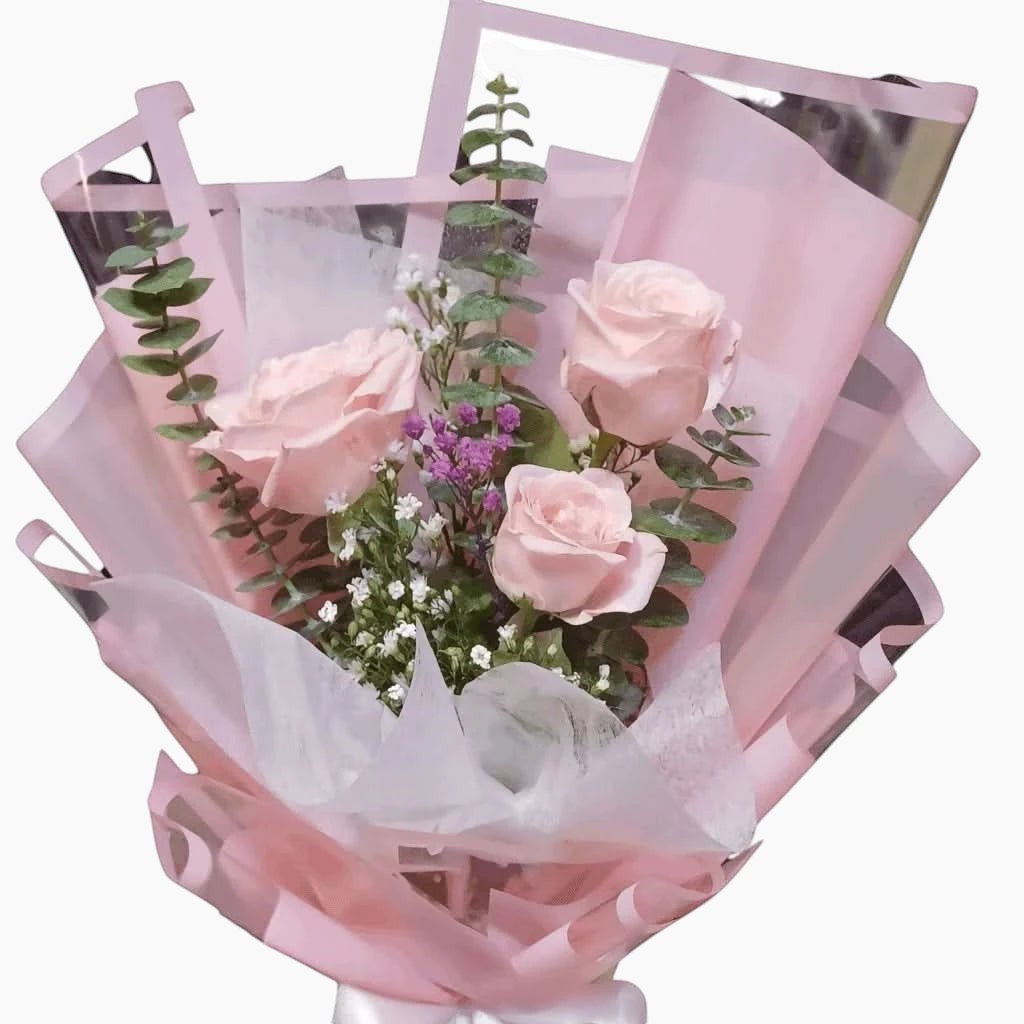 The Flowercart Rosa bouquet featuring three pink roses, eucalyptus, and gypsophila wrapped in soft pink paper.