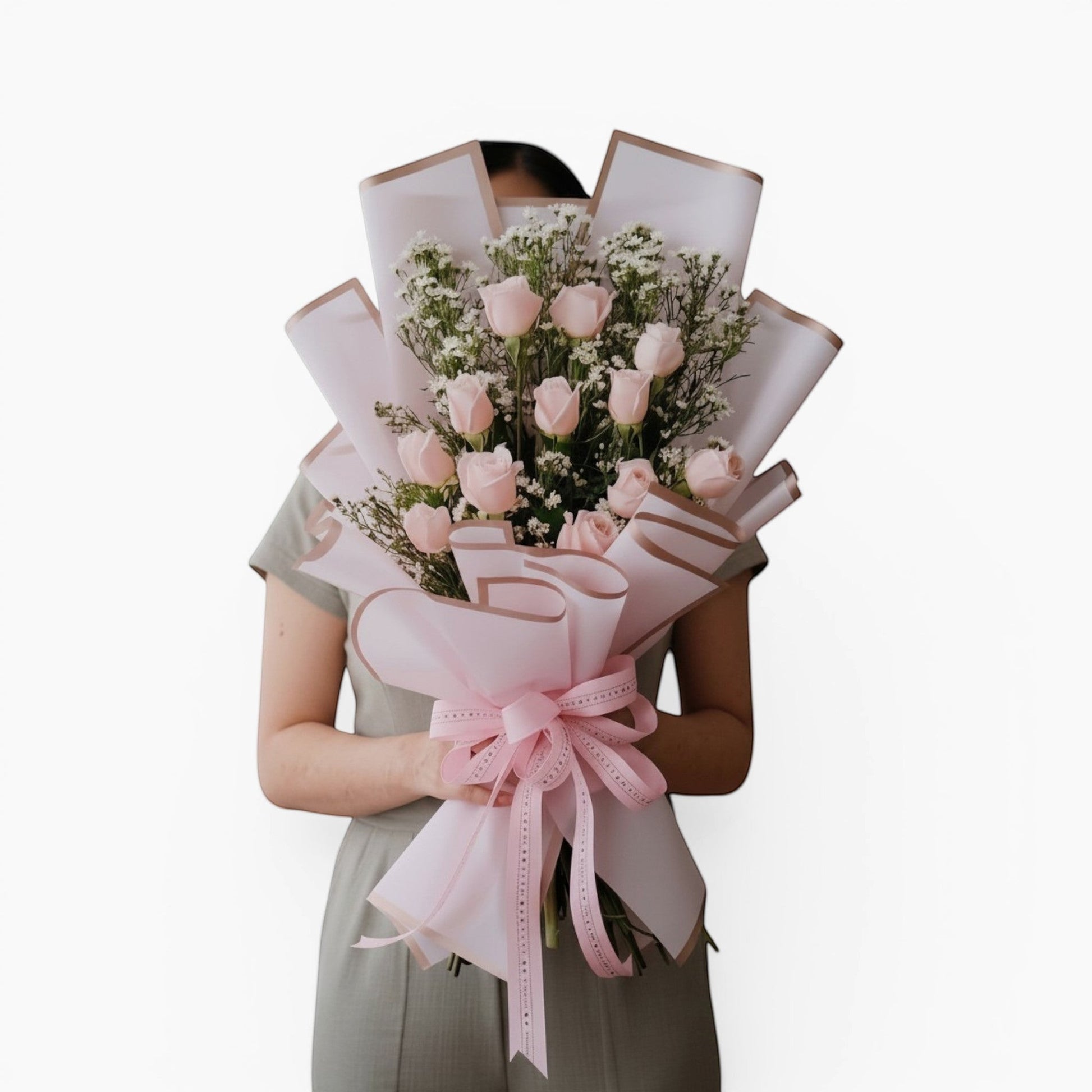 The Flowercart Autumn Morning bouquet featuring 12 soft pink roses and white fillers wrapped in elegant pink paper.