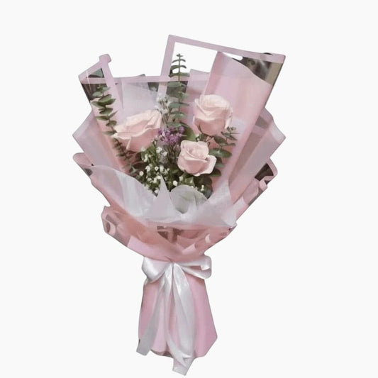 The Flowercart Rosa bouquet featuring three pink roses, eucalyptus, and gypsophila wrapped in soft pink paper.