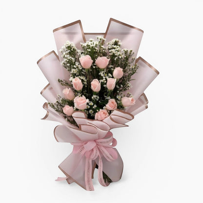 The Flowercart Autumn Morning bouquet featuring 12 soft pink roses with white fillers in elegant pink wrapping.