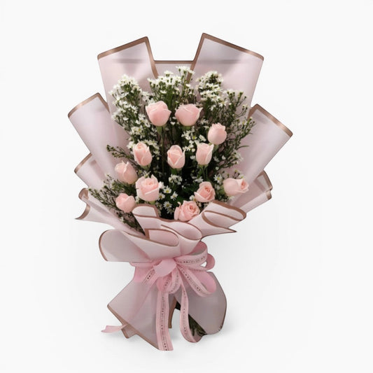 The Flowercart Autumn Morning bouquet featuring 12 soft pink roses with white fillers in elegant pink wrapping.