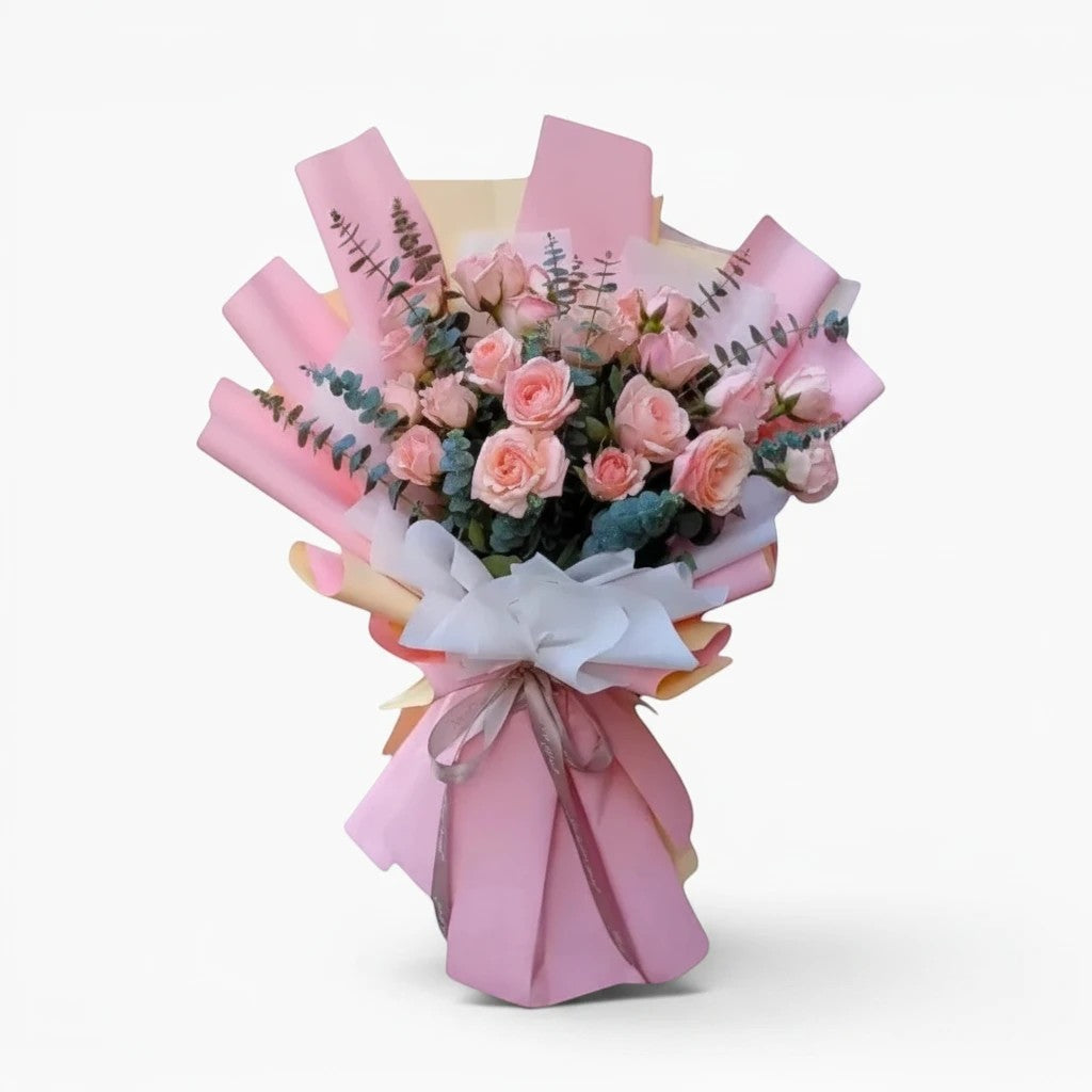 The Flowercart bouquet featuring 24 soft pink roses and eucalyptus wrapped in elegant pink and white paper.