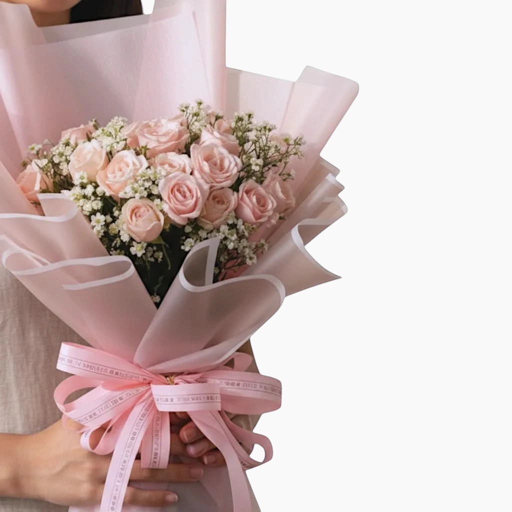 The Flowercart bouquet of 24 soft pink roses and baby's breath wrapped in elegant pink paper with a matching ribbon.