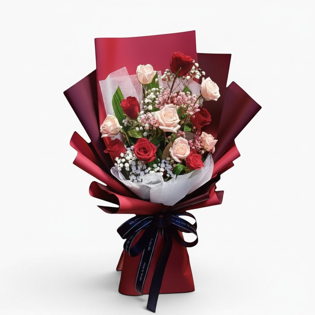 The Flowercart Wendy's Bouquet featuring red and pink roses with baby's breath in elegant dark red wrapping.