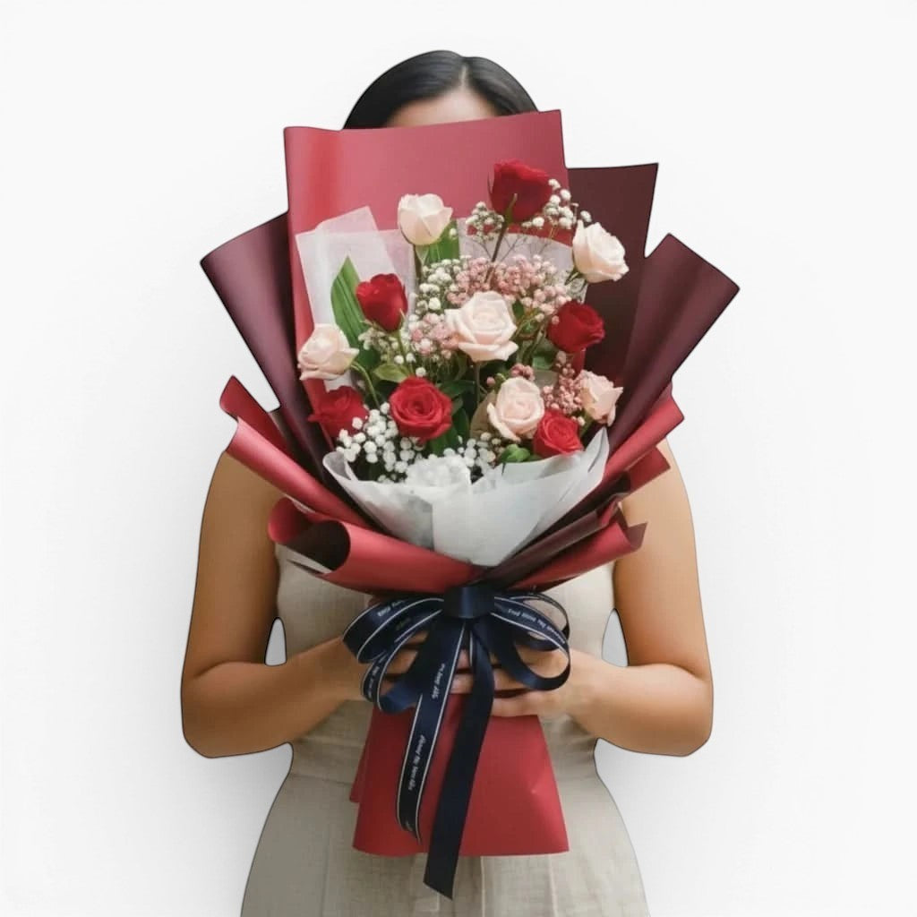 The Flowercart Wendy's Bouquet featuring red and pink roses with baby's breath wrapped in elegant dark red paper.