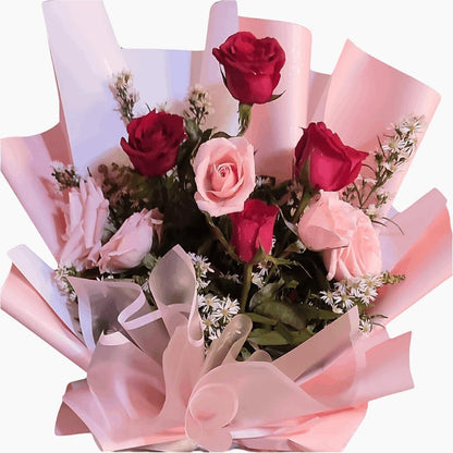 The Flowercart Caribbean Twist bouquet featuring red and pink roses wrapped in soft pink decorative paper.