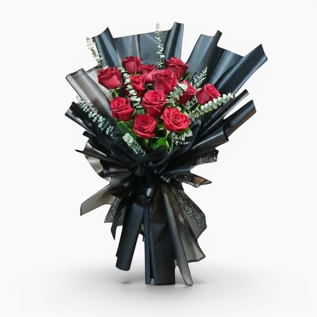 The Flowercart Maison Fleur bouquet featuring 12 red Ecuadorian roses and fresh eucalyptus in elegant black wrapping.