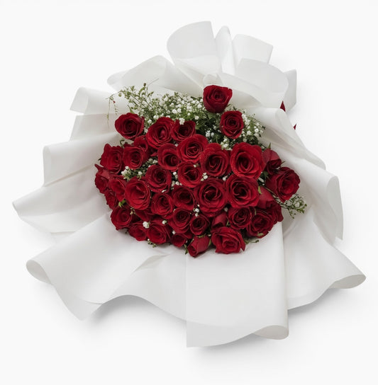 The Flowercart Forever Spring bouquet featuring 48 red roses and white baby's breath wrapped in elegant white paper.