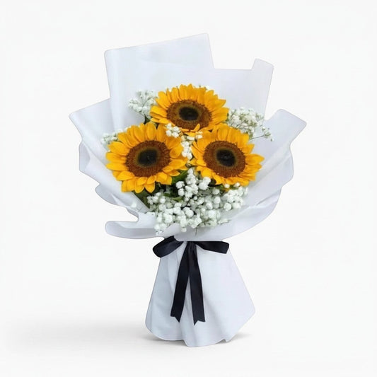 The Flowercart Hello Sunshine bouquet featuring three bright yellow sunflowers and white baby's breath in white wrap.
