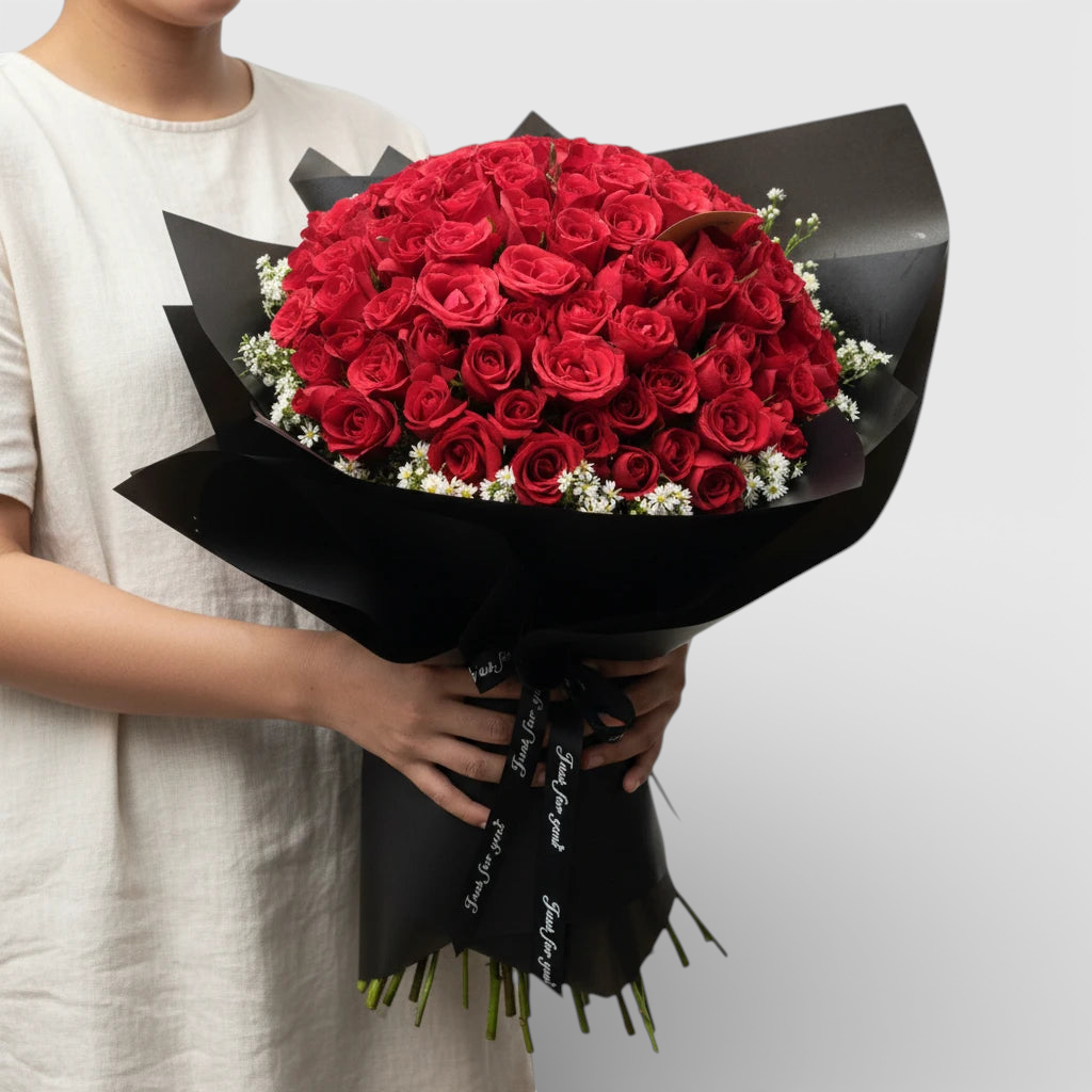 The Flowercart's Meadow Fresh bouquet: 100 crimson roses with baby's breath, wrapped in black paper. Perfect for proposals.