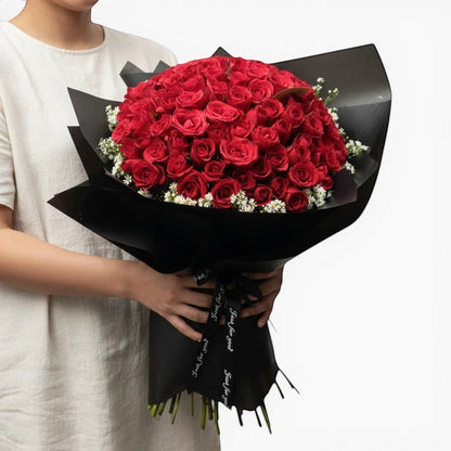 The Flowercart's Meadow Fresh bouquet: 100 crimson roses with baby's breath, wrapped in black paper. Perfect for proposals.