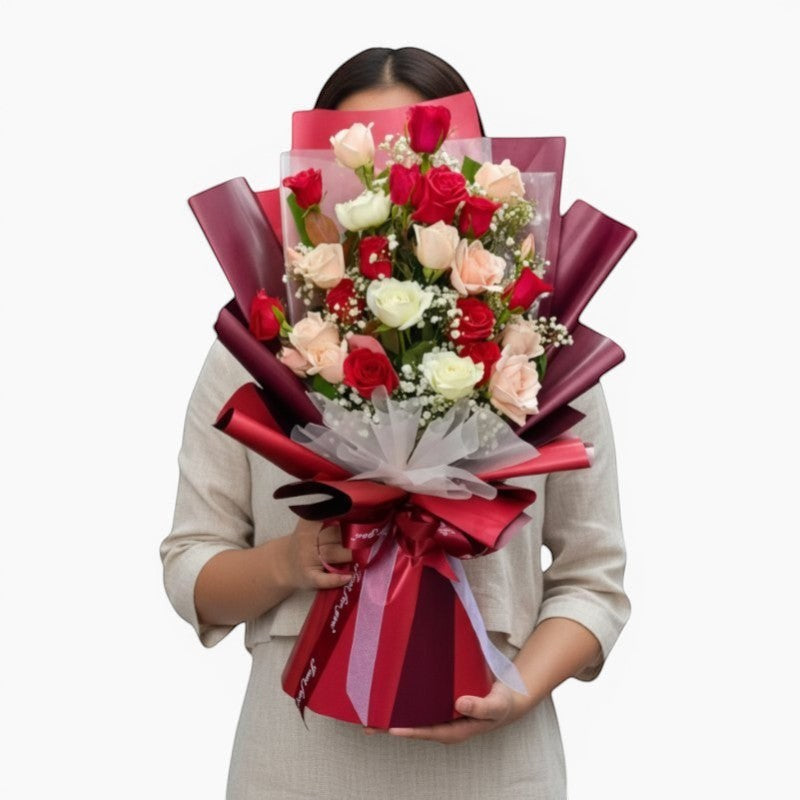 The Flowercart Hermosa bouquet: 24 red, white, and pink roses with baby's breath, elegantly wrapped in burgundy.