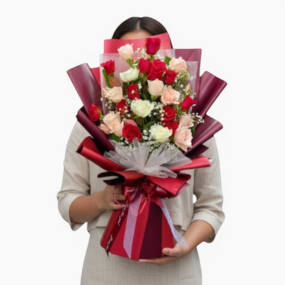 The Flowercart Hermosa bouquet: 24 red, white, and pink roses with baby's breath, elegantly wrapped in burgundy.