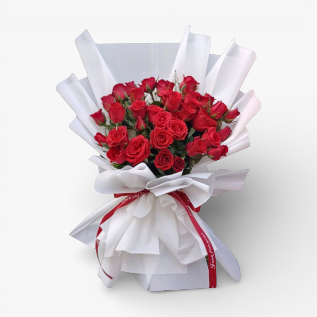 The Flowercart 36 red roses bouquet, elegantly wrapped in white paper with a red ribbon, perfect for anniversaries and romantic occasions.