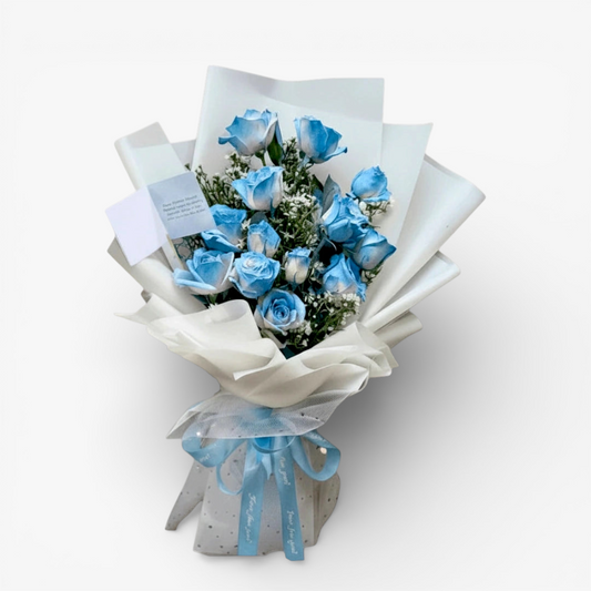 The Flowercart 12 blue roses bouquet with white wrapping and blue ribbon. Perfect for unique gifts.