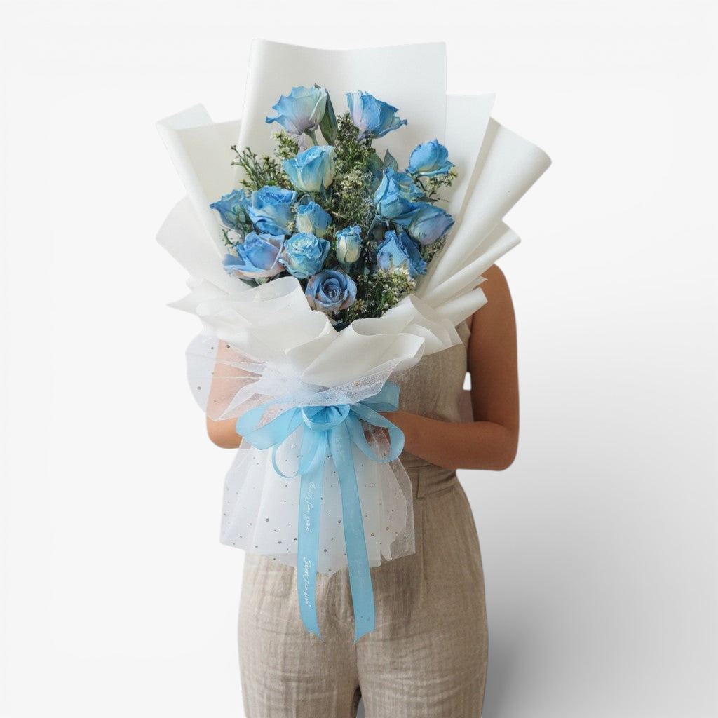 The Flowercart 12 blue roses bouquet with white wrapping and blue ribbon, perfect for unique occasions.