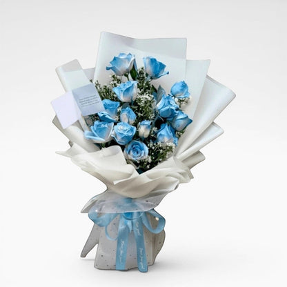 The Flowercart 12 blue roses bouquet with white wrapping and blue ribbon. Perfect for unique gifts.