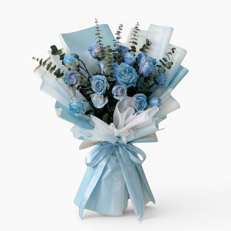 The Flowercart's unique bouquet of 24 blue spray roses and eucalyptus, wrapped in light blue and white paper with a blue ribbon.
