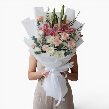 The Flowercart Caitlyn bouquet: 24 white & pink roses, Stargazer lilies, eucalyptus, gypsophila. Elegant floral arrangement.